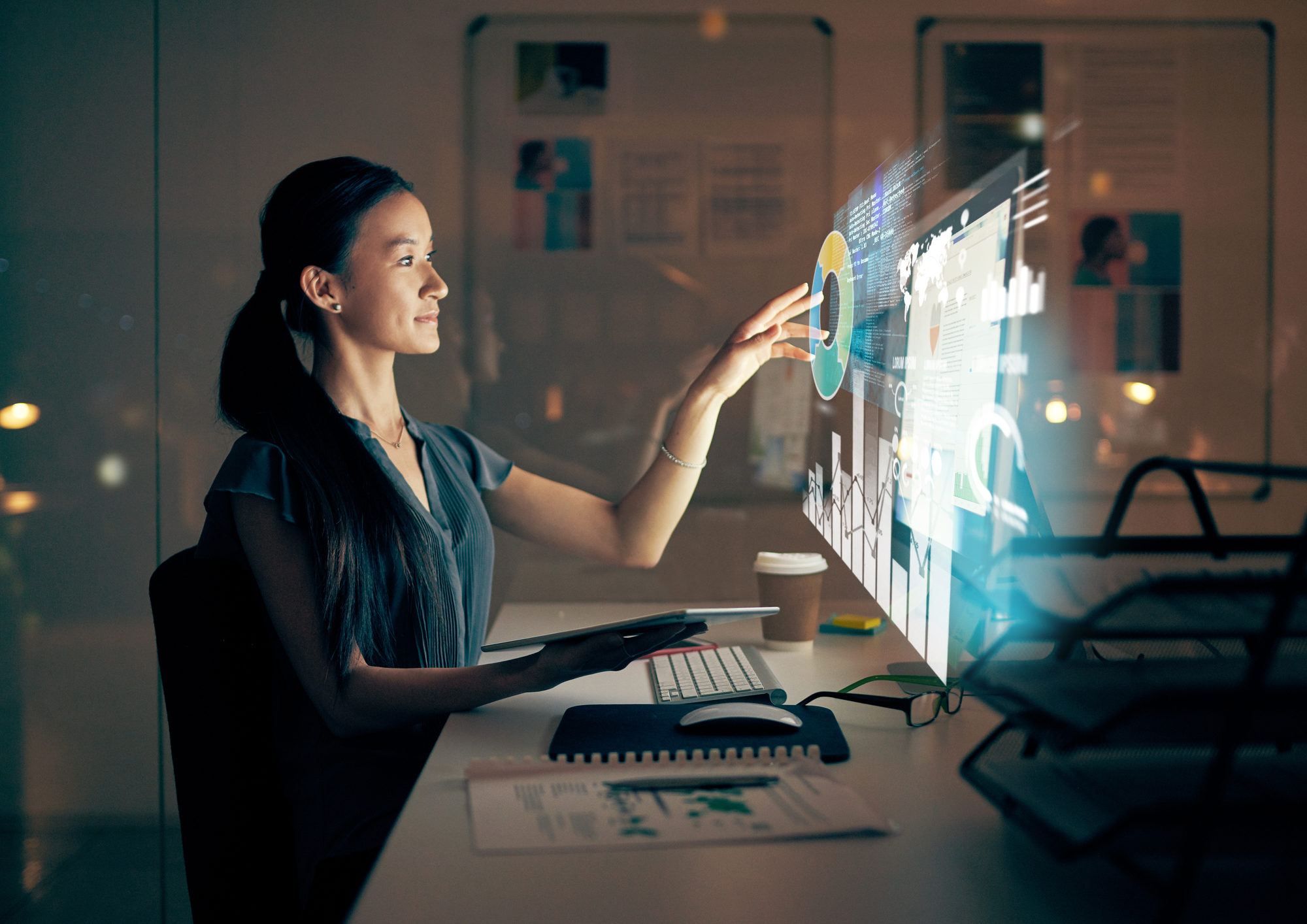 businesswoman using a modern digital tablet at night in her office