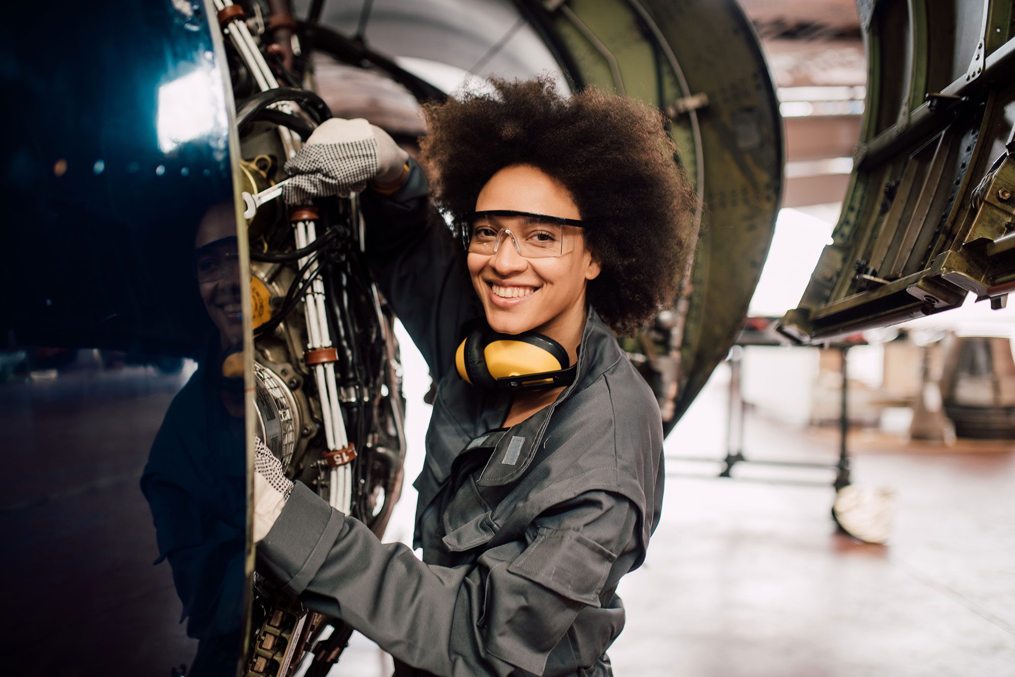 Happy woman repairing aircraft