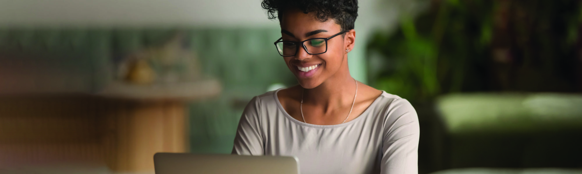Happy african american woman using laptop work study in office