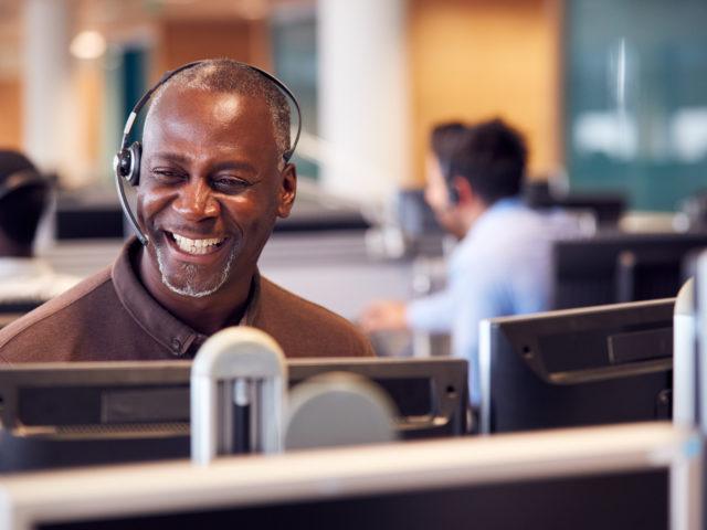 smiling man with headset in call centre