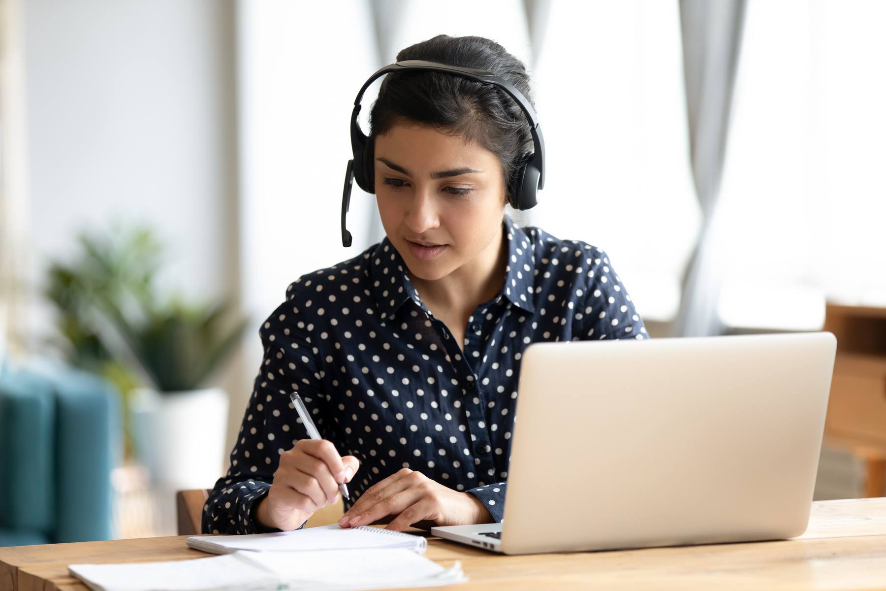 businesswoman with headset working on her laptop