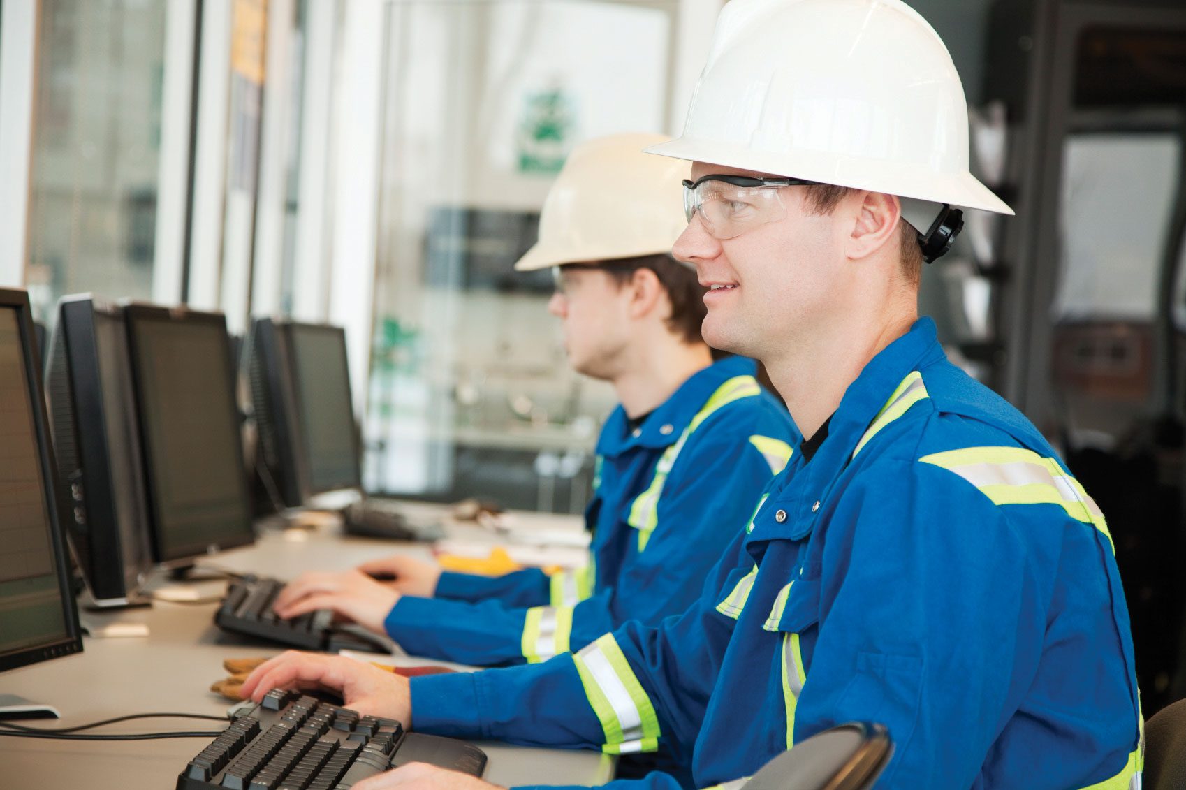 Men in hardhats on computers