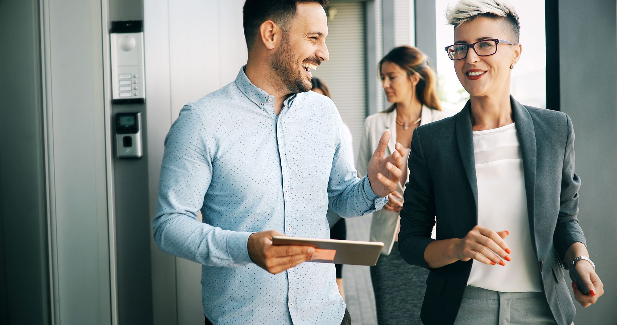 businessman laughing and showing coworker information on tablet