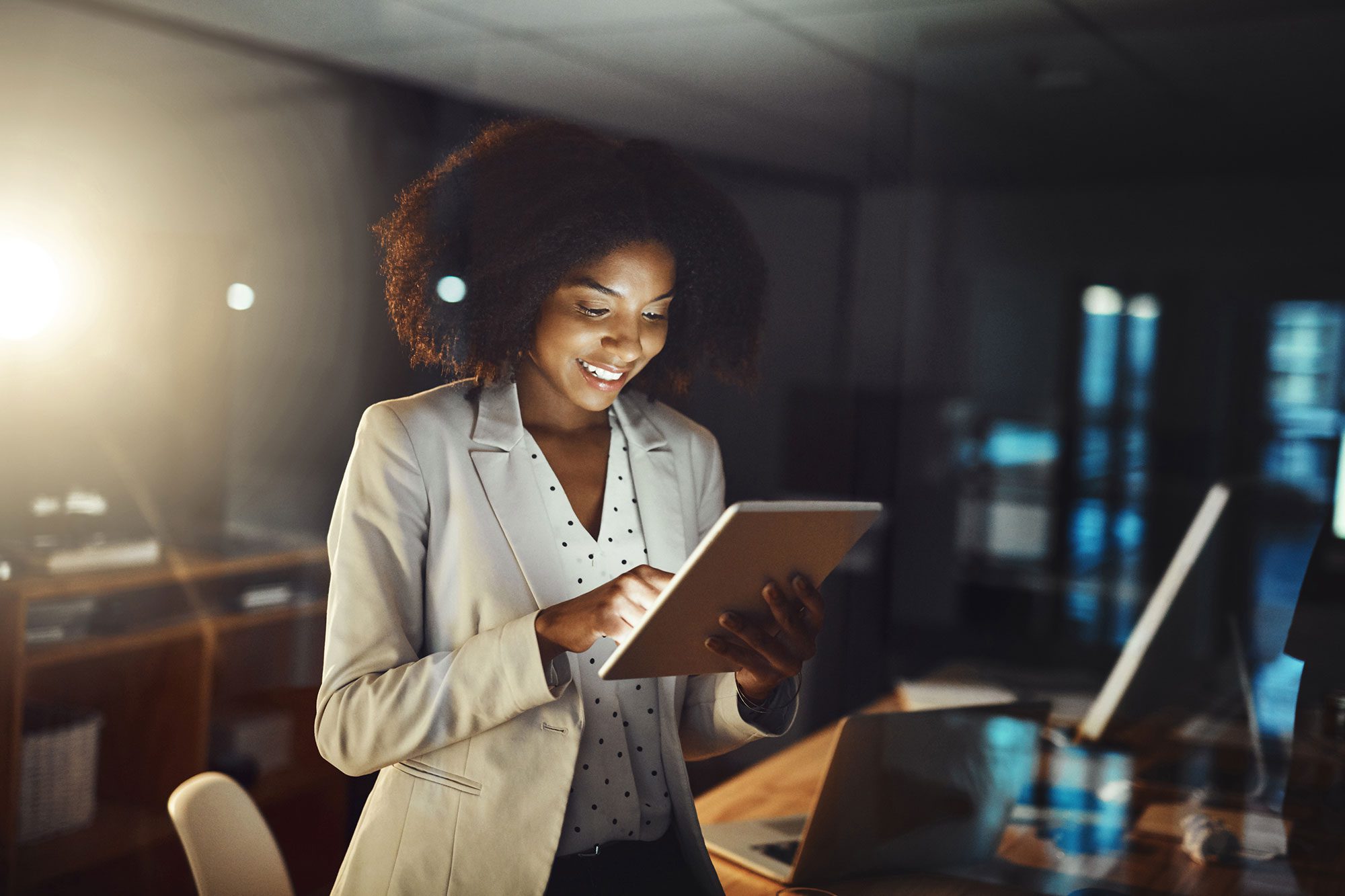 smiling businesswoman tapping away on her tablet