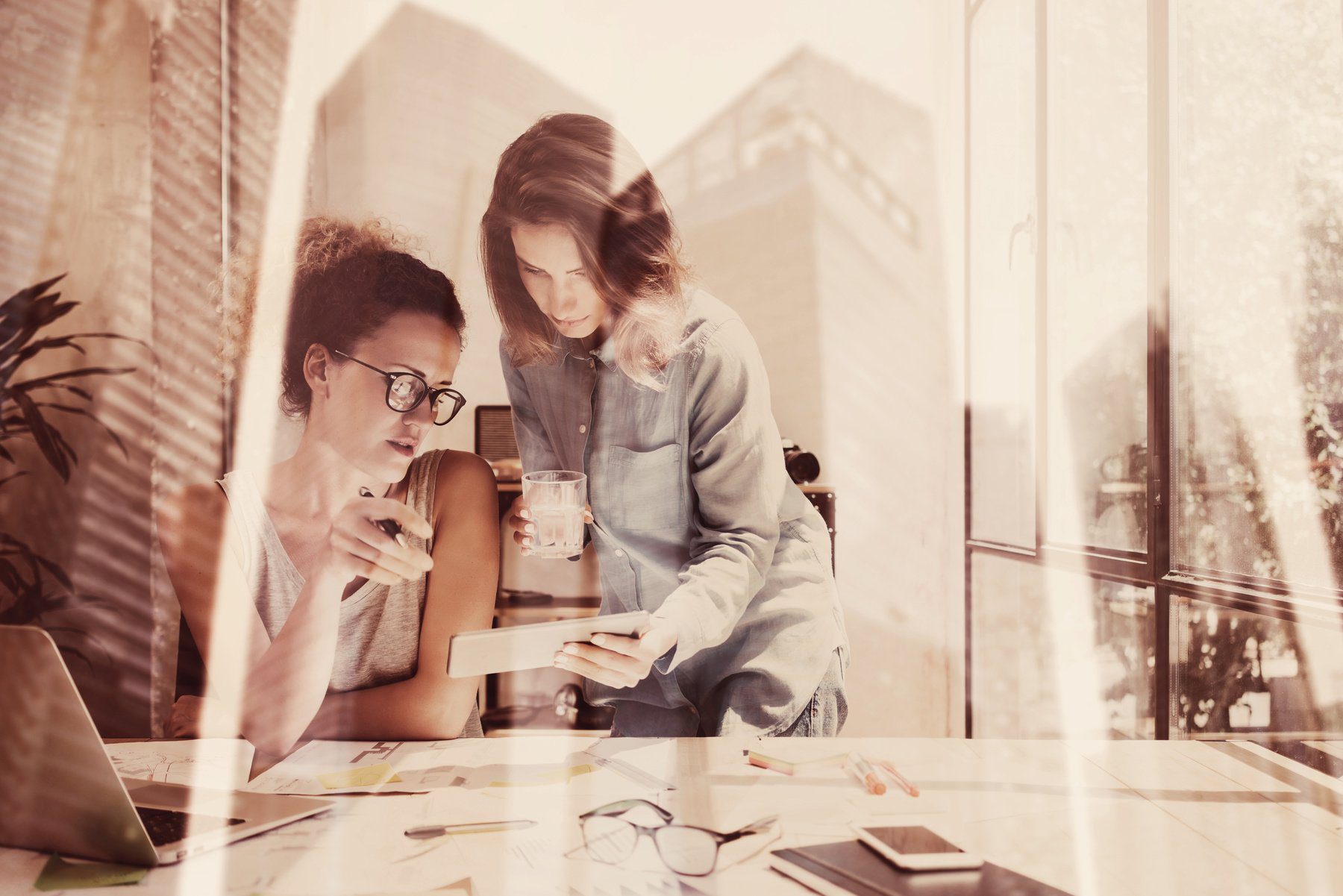 two coworkers looking at cellular device at a modern workplace