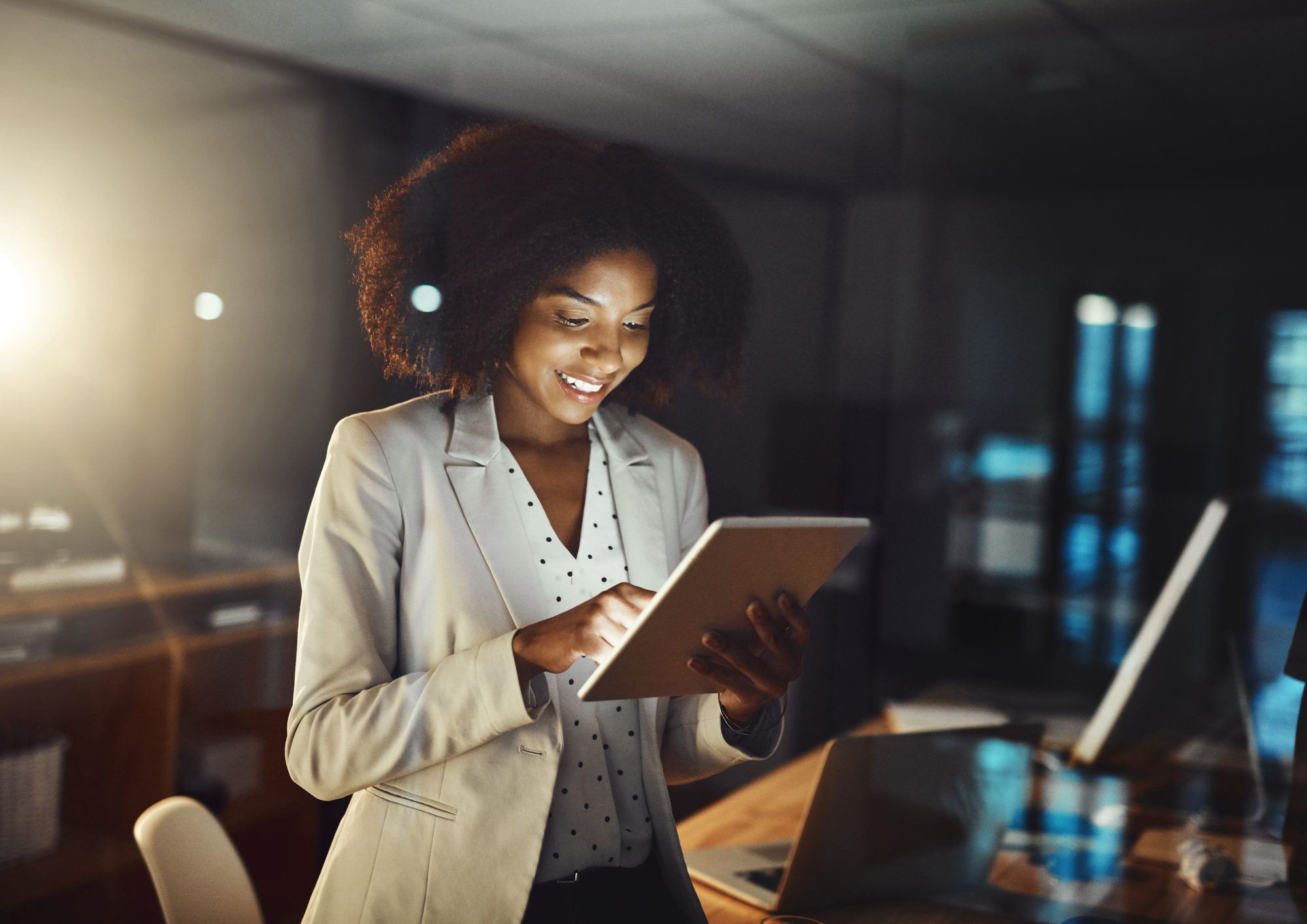 learning and transformation - A professional woman looking at her tablet while smiling