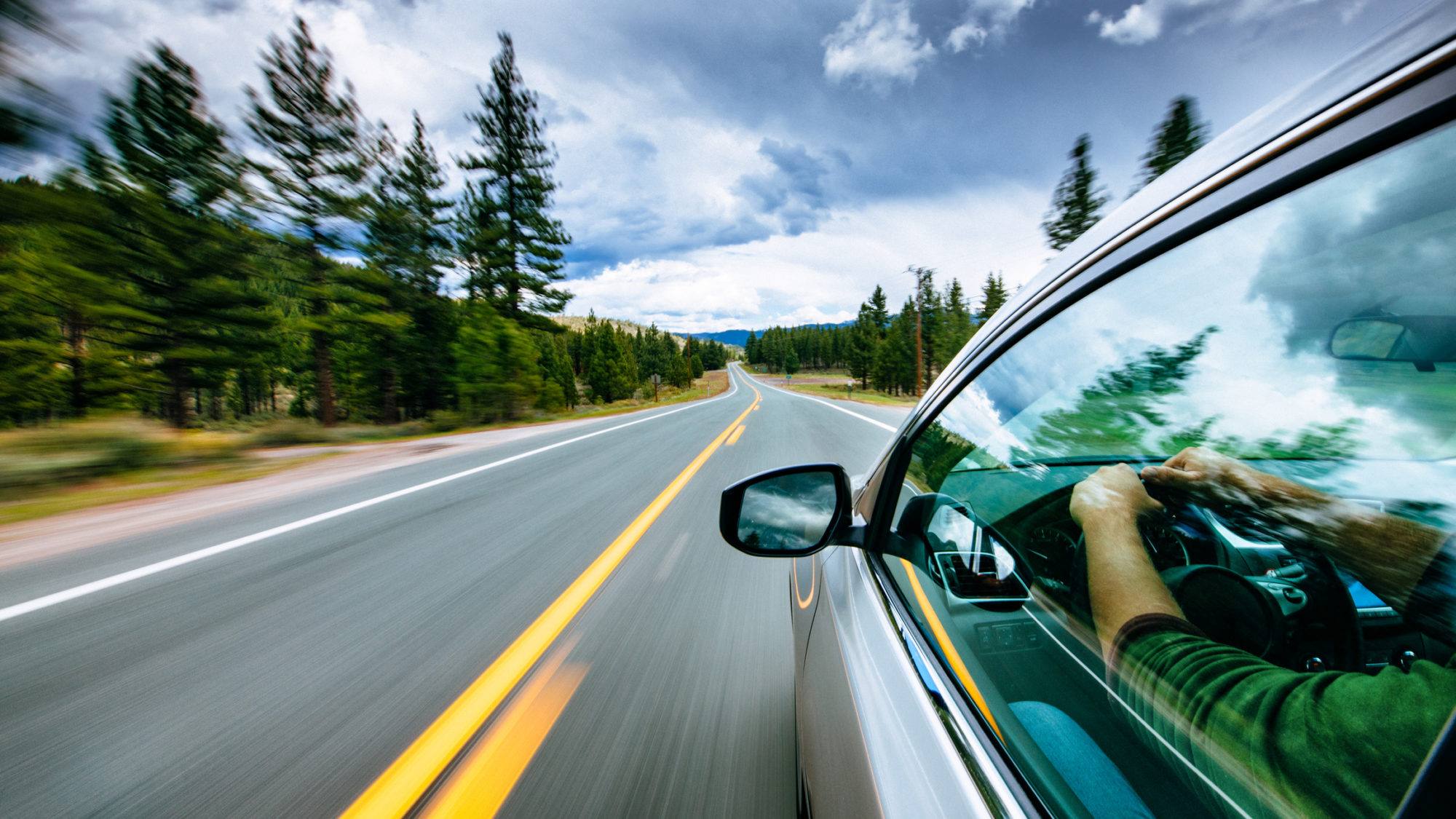 man driving car on empty road