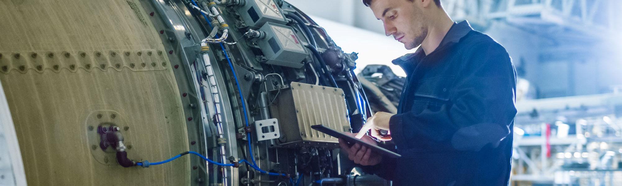 Aerospace engineer working on engine using tablet