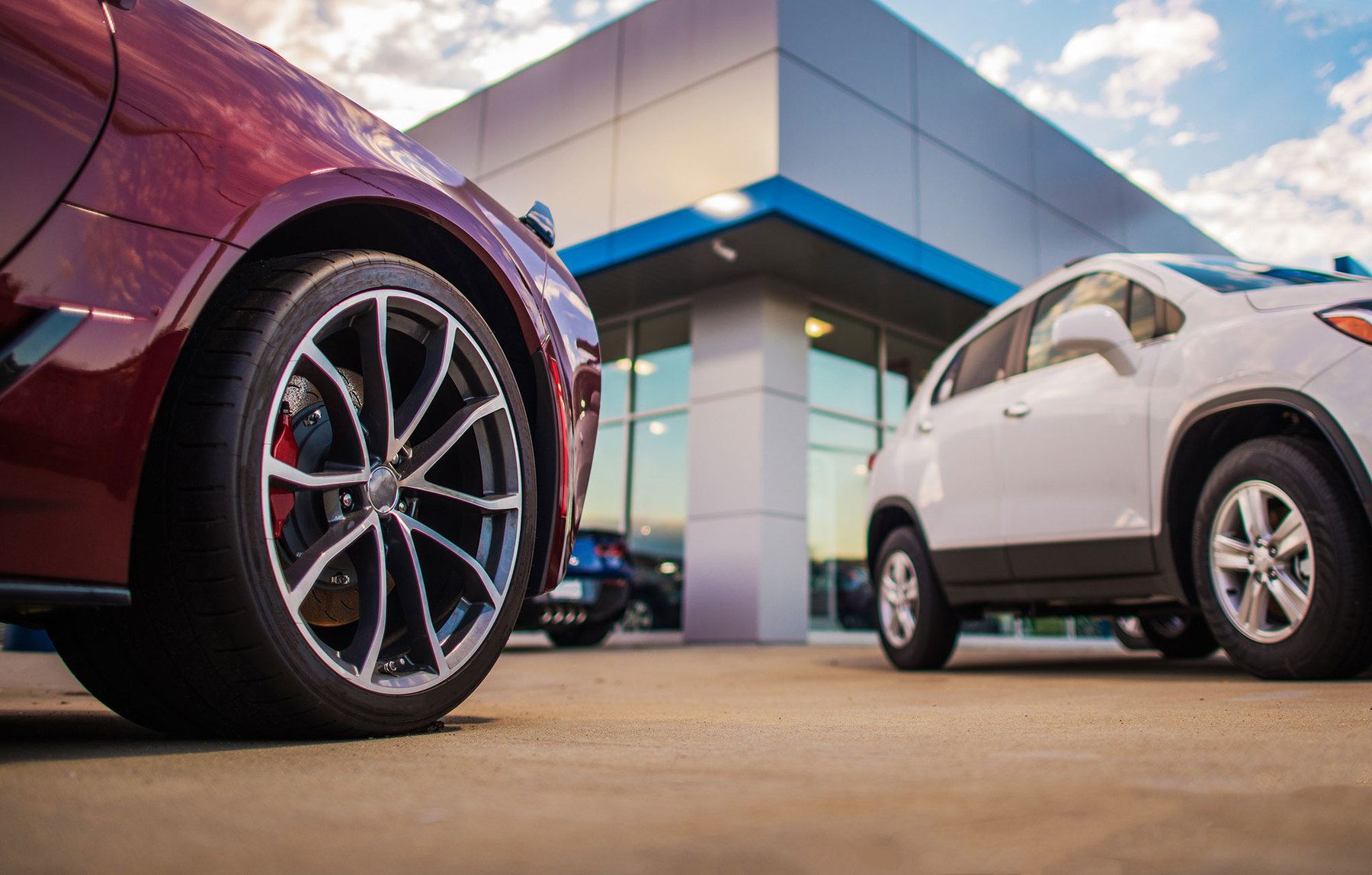 brand new cars parking in front of car dealership