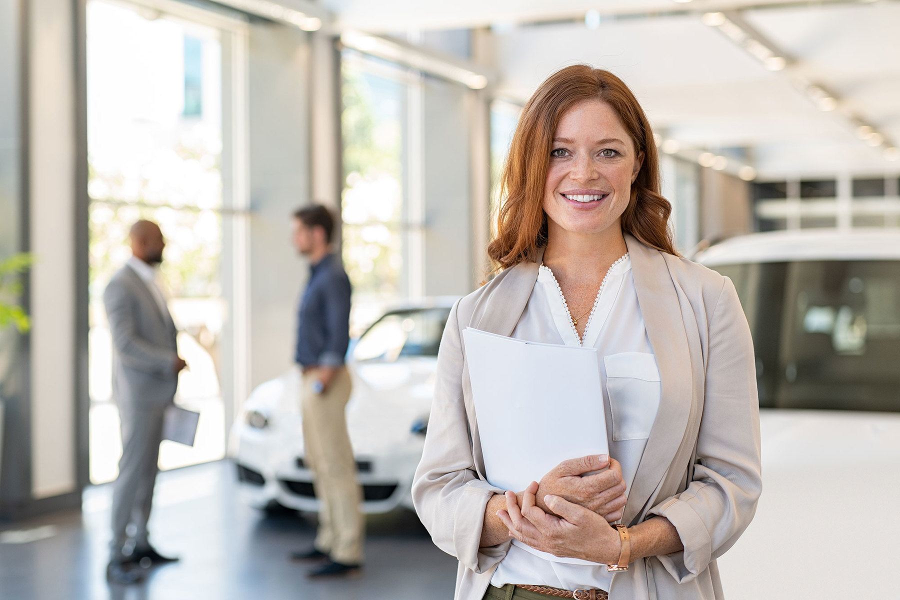 car saleswoman smiling inside car dealership