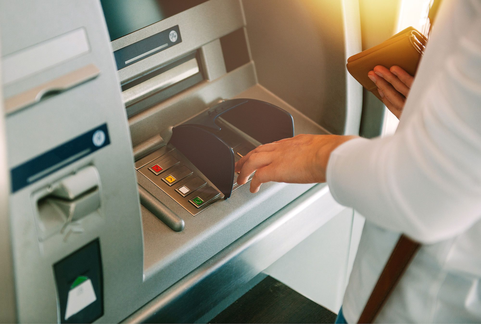 man typing on atm pin pad