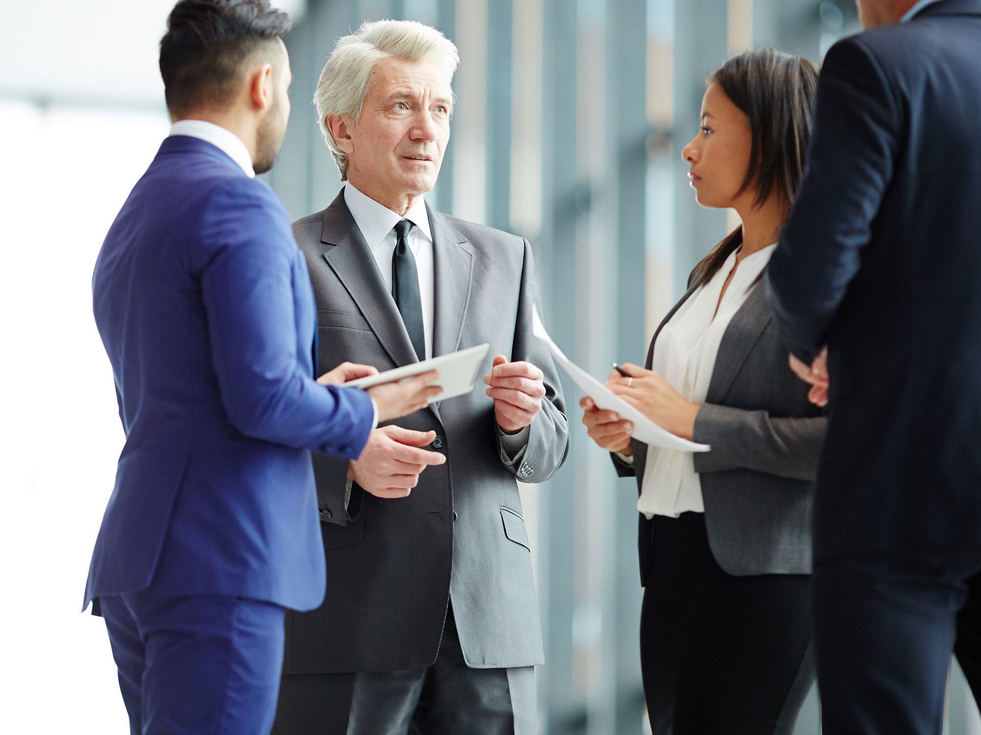 businessmen and businesswoman talking and taking notes