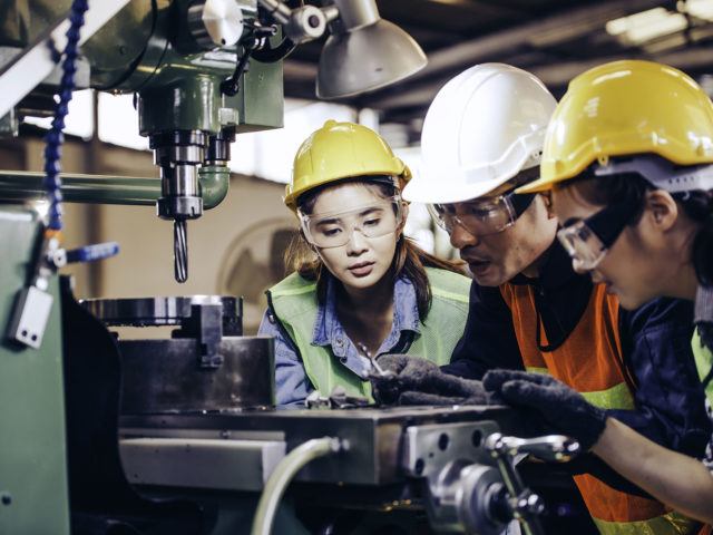 heavy industry workers working on machine part